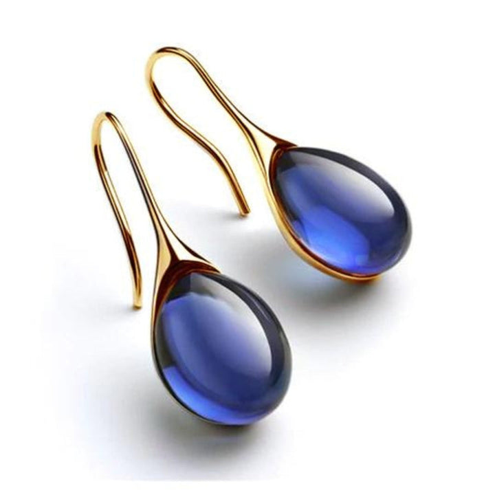 "Pendientes de Cristal en Oro y Plata" can be rewritten as "Aretes de Cristal en Oro y Plata".