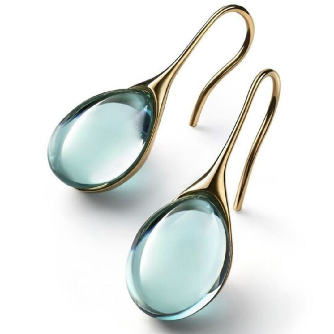 "Pendientes de Cristal en Oro y Plata" can be rewritten as "Aretes de Cristal en Oro y Plata".